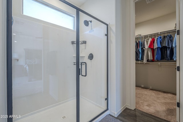 17618 W Medlock Dr, Litchfield Park, AZ 85340 - bathroom with a shower stall, a walk in closet, wood finished floors, and baseboards
