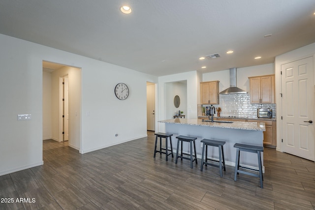 17618 W Medlock Dr, Litchfield Park, AZ 85340 - kitchen featuring wall chimney exhaust hood, a center island with sink, a sink, decorative backsplash, and recessed lighting
