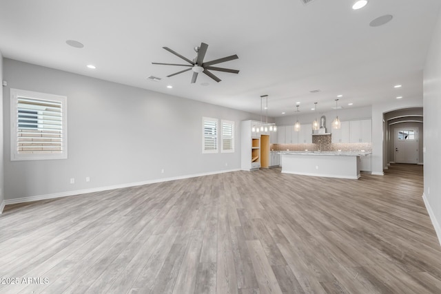 unfurnished living room with ceiling fan and light hardwood / wood-style floors