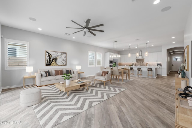 living room featuring ceiling fan, a healthy amount of sunlight, and light hardwood / wood-style floors