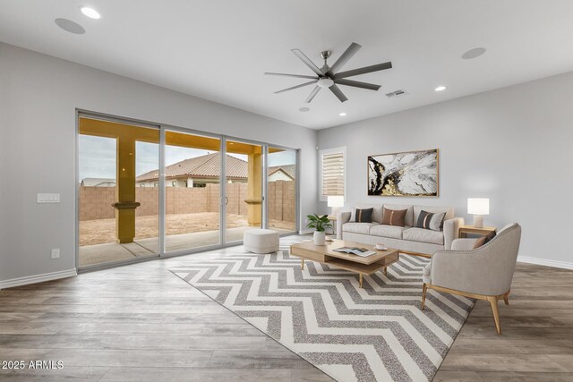 living room featuring ceiling fan and light hardwood / wood-style floors