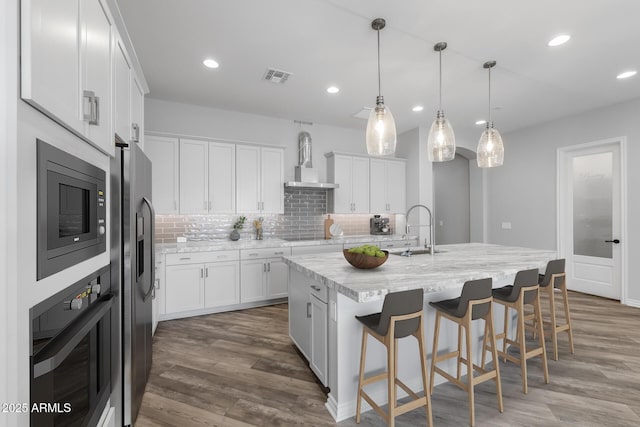 kitchen featuring black appliances, sink, wall chimney range hood, and white cabinetry