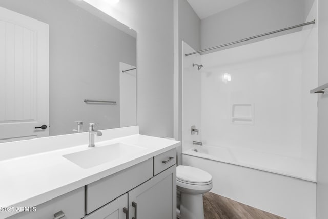 full bathroom with hardwood / wood-style flooring, toilet, vanity, and  shower combination