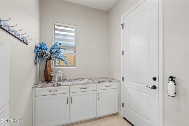 laundry area with light tile patterned floors