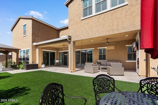 rear view of property with outdoor lounge area, ceiling fan, a yard, and a patio