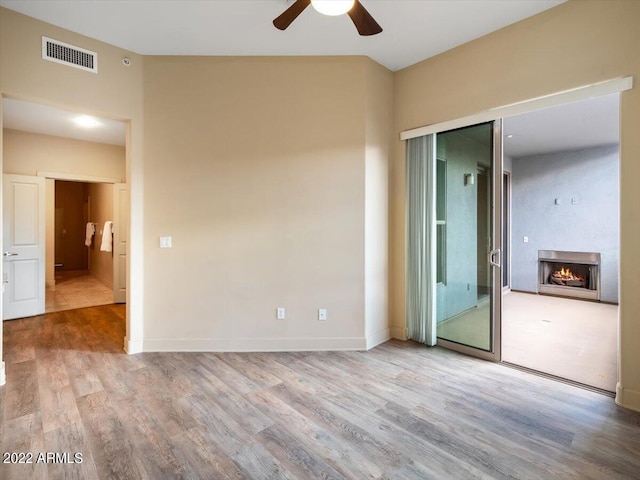 unfurnished bedroom featuring hardwood / wood-style flooring, vaulted ceiling, and ceiling fan