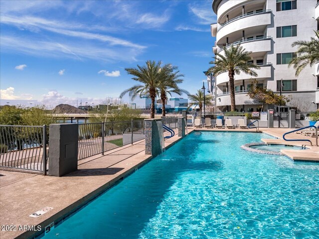 view of swimming pool with a community hot tub