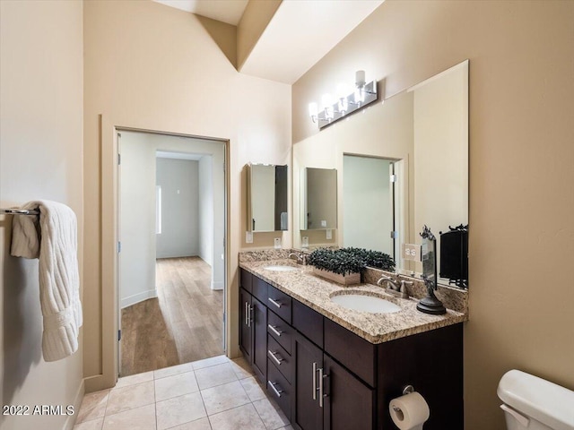 bathroom featuring double vanity, tile patterned flooring, and toilet