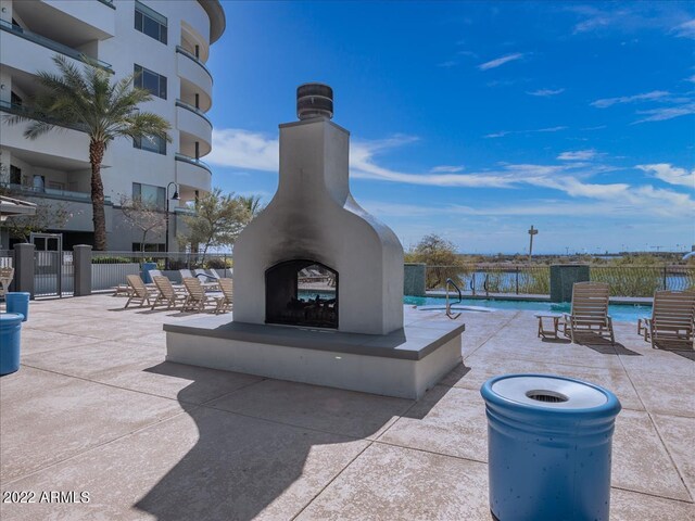 view of patio / terrace with exterior fireplace and a community pool