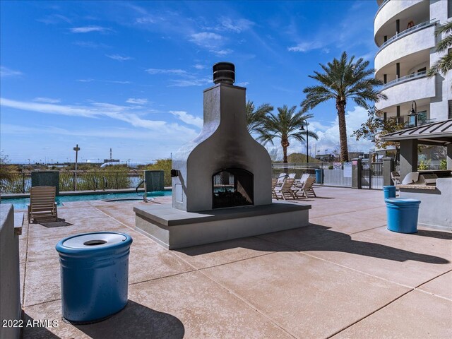 view of patio / terrace featuring a community pool and a multi sided fireplace