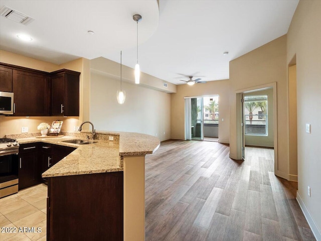 kitchen featuring ceiling fan, sink, light stone counters, light hardwood / wood-style floors, and appliances with stainless steel finishes