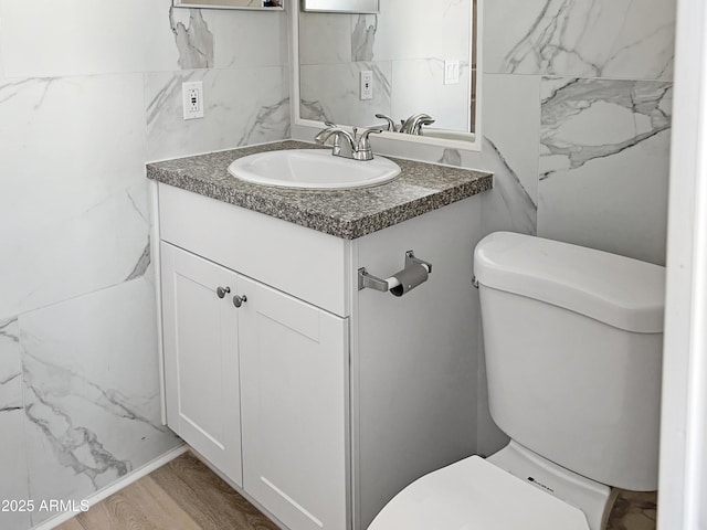 bathroom featuring hardwood / wood-style flooring, toilet, and vanity