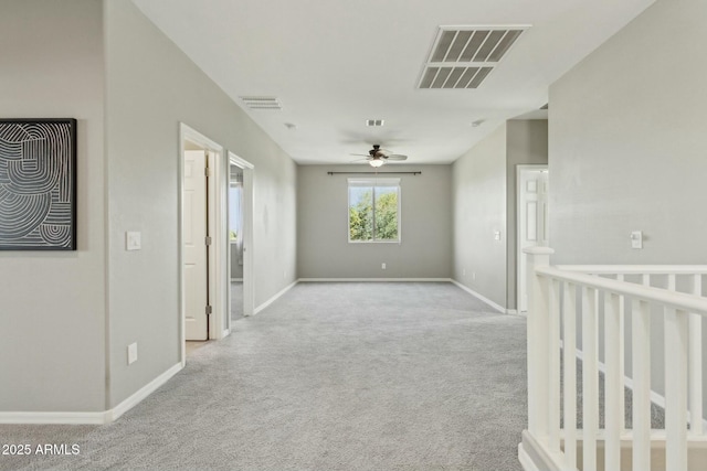 unfurnished room with light colored carpet and ceiling fan