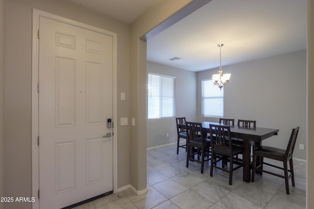 tiled dining area featuring a chandelier