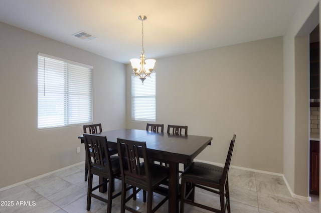 tiled dining room with a healthy amount of sunlight and a notable chandelier