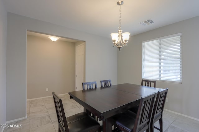 dining space with a notable chandelier and light tile patterned floors