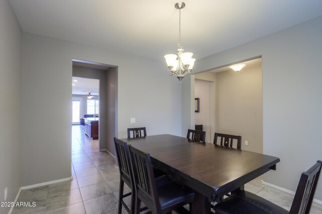 dining room featuring light tile patterned floors and ceiling fan with notable chandelier