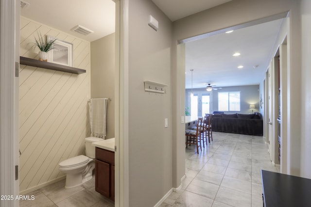 hall featuring wood walls and light tile patterned floors