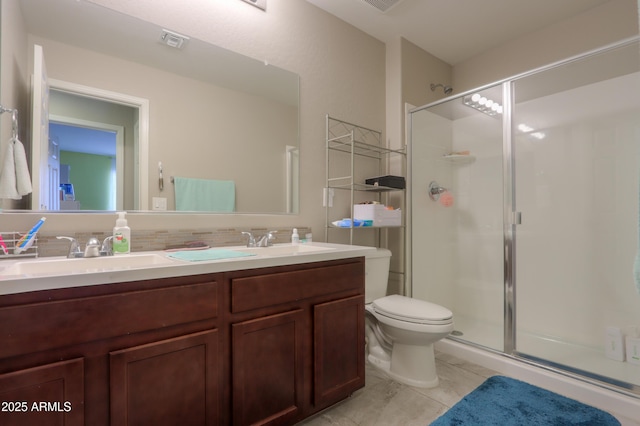 bathroom featuring tile patterned flooring, vanity, toilet, and a shower with door