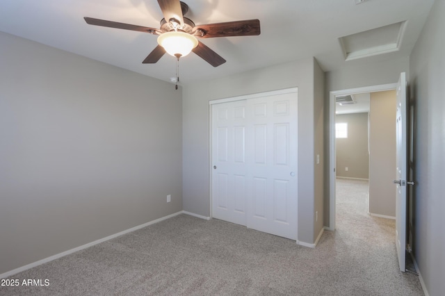 unfurnished bedroom featuring a closet, ceiling fan, and light colored carpet