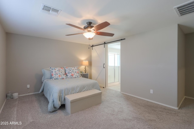 carpeted bedroom featuring a barn door and ceiling fan