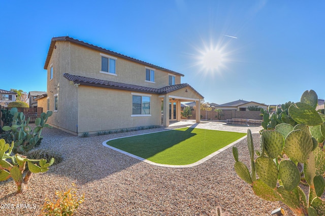 back of house with a lawn and a patio