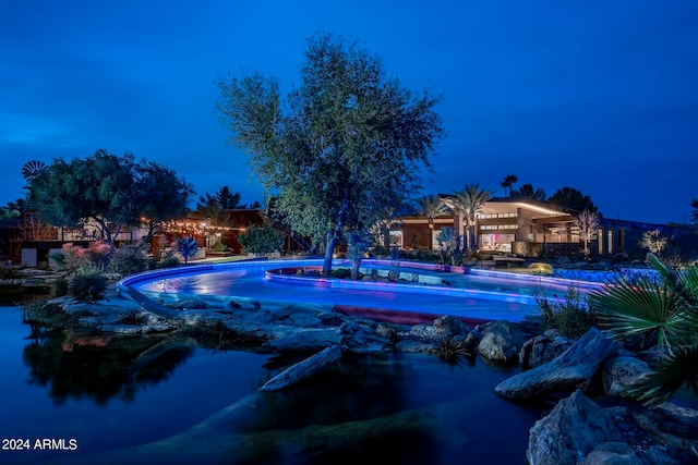 view of pool at twilight