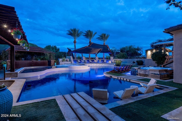 pool at dusk featuring a patio area, an in ground hot tub, and a lawn