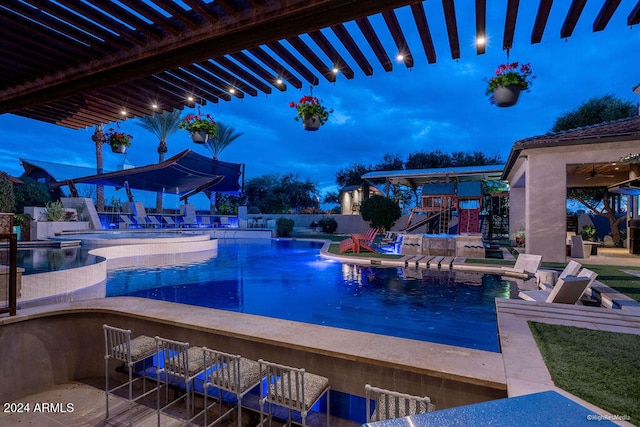 pool at dusk featuring a patio and a bar