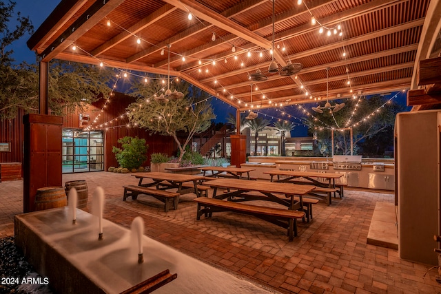 patio at twilight with exterior kitchen and a grill