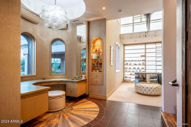 bathroom featuring tile patterned floors, sink, a chandelier, and a high ceiling