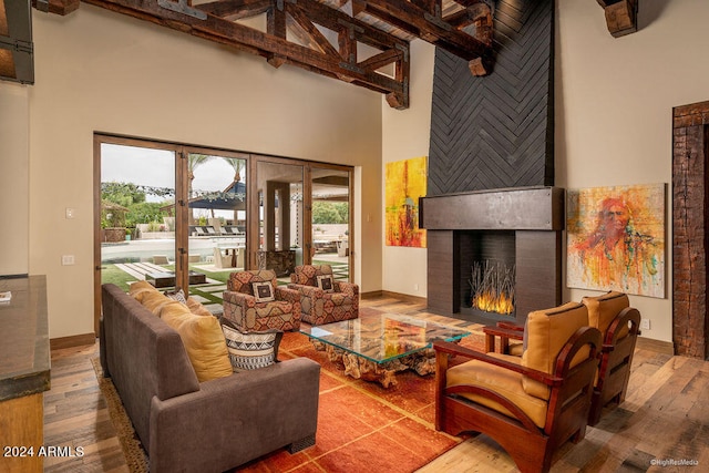 living room with hardwood / wood-style flooring, high vaulted ceiling, and beamed ceiling