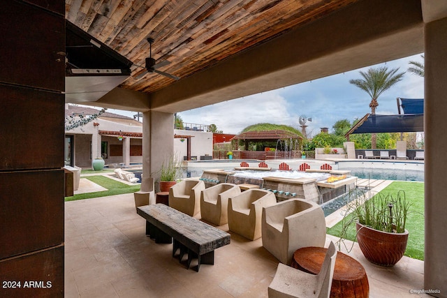 view of patio featuring a fenced in pool, an outdoor kitchen, exterior bar, and ceiling fan