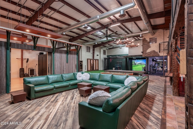 living room featuring hardwood / wood-style flooring, beamed ceiling, wooden walls, and ceiling fan