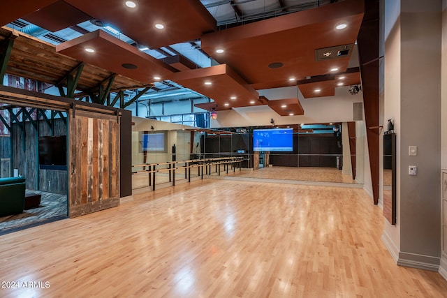 misc room featuring light hardwood / wood-style flooring and a high ceiling