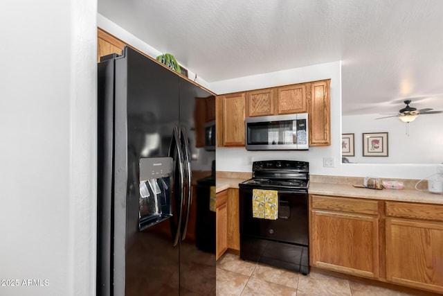 kitchen featuring black appliances, light countertops, and brown cabinetry