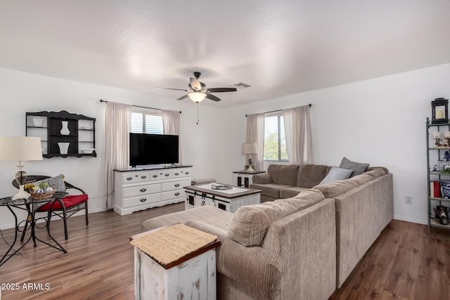 living room with a ceiling fan, baseboards, visible vents, and dark wood-type flooring