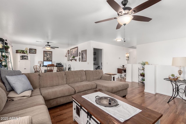 living room featuring dark wood-style flooring and ceiling fan