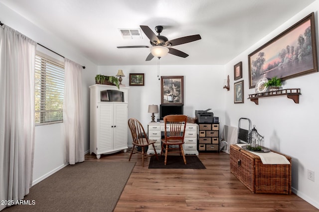 dining room with a ceiling fan, baseboards, visible vents, and wood finished floors