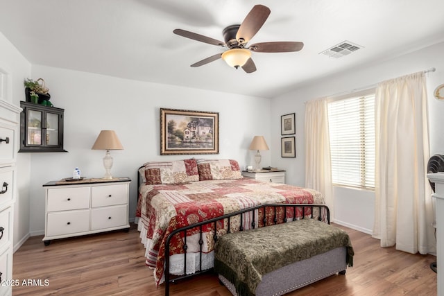 bedroom with dark wood-style floors, visible vents, and baseboards