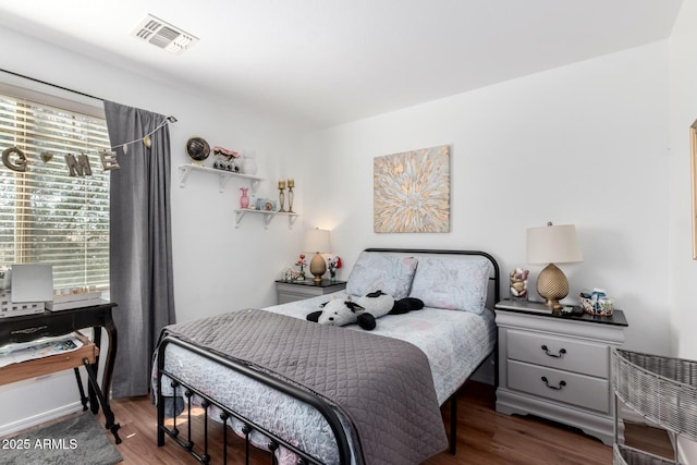 bedroom with dark wood-type flooring and visible vents