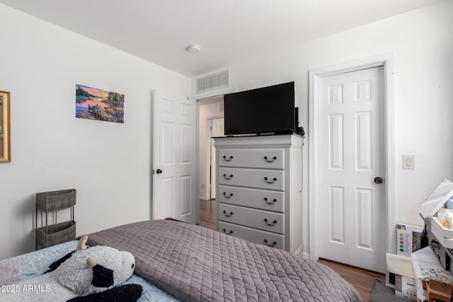 bedroom featuring wood finished floors and visible vents