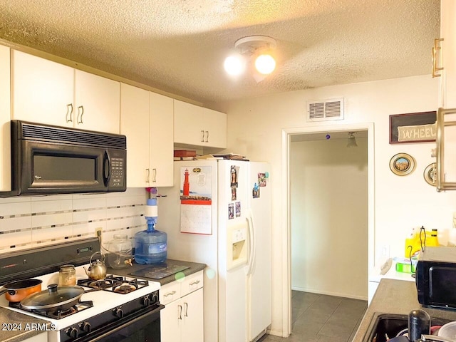 kitchen with range, white fridge with ice dispenser, white cabinets, and dark tile patterned flooring