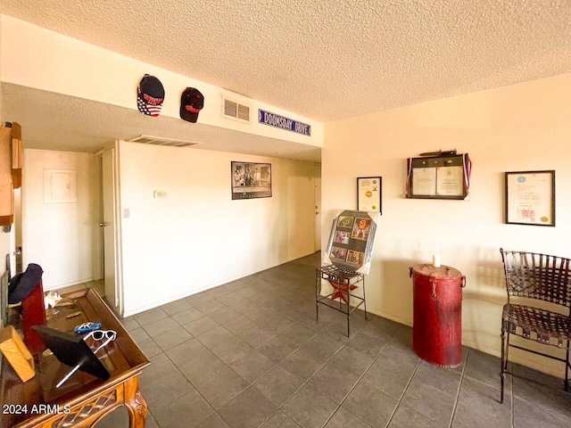 interior space featuring dark tile patterned flooring and a textured ceiling