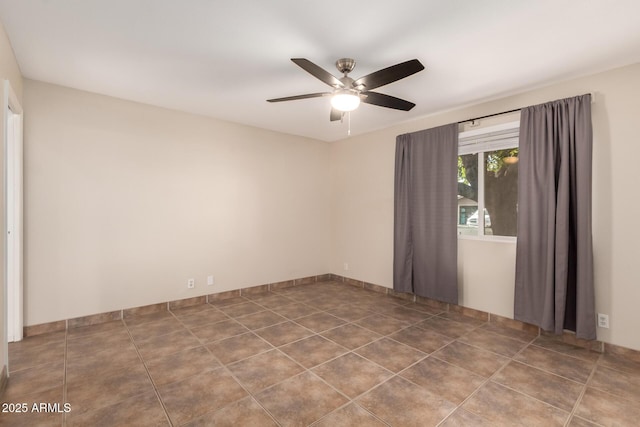 tiled spare room with a ceiling fan