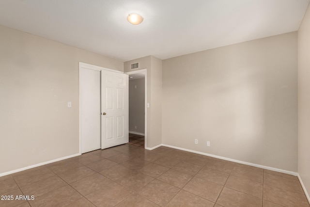 tiled spare room with visible vents and baseboards