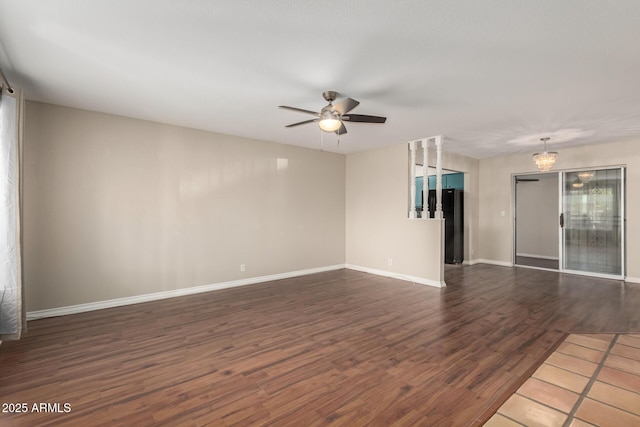 empty room featuring dark wood-style flooring, baseboards, and a ceiling fan