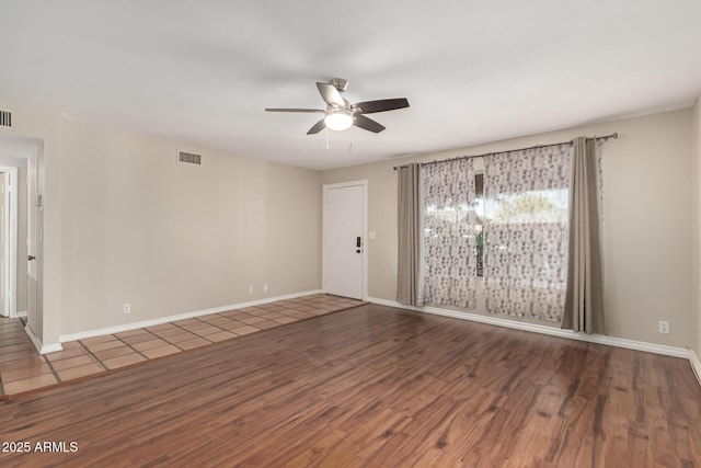 unfurnished living room featuring visible vents, baseboards, wood finished floors, and ceiling fan