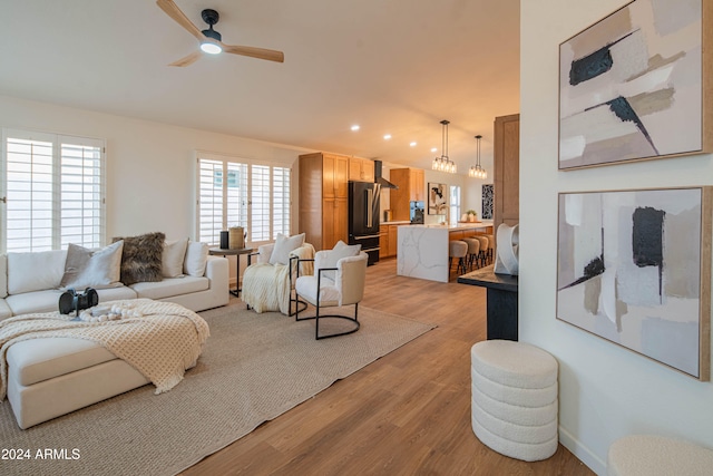 living room with light hardwood / wood-style floors and ceiling fan