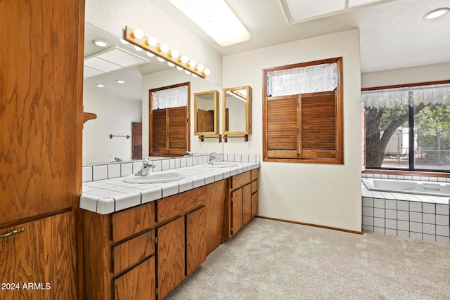 bathroom featuring tiled bath and vanity